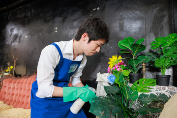 花の手入れをするエプロンを着た日本人男性