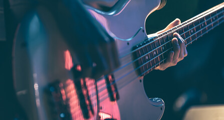 Close-up of a man playing the bass guitar.