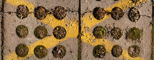 Parking lot texture. Yellow X mark painted on harsh concrete plates.