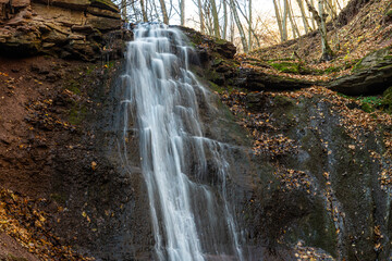 Fototapeta premium Tranquil waterfall scenery in the middle of autumn forest