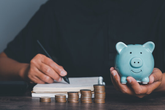 Woman hand holding piggy bank on wood table, saving money wealth and financial concept, Business, finance, investment, Financial planning,vintage picture style concept.