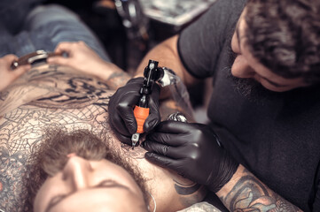 Professional tattooist create tattoo in the salon