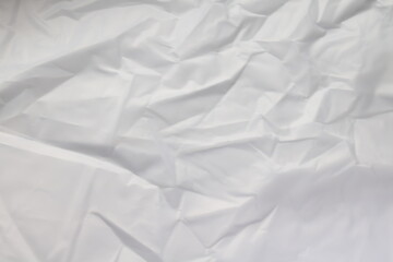Crumpled white paper background texture.