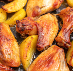 Baked chicken and potatoes in the oven as a background.