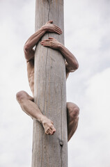 Man climbing on post pole