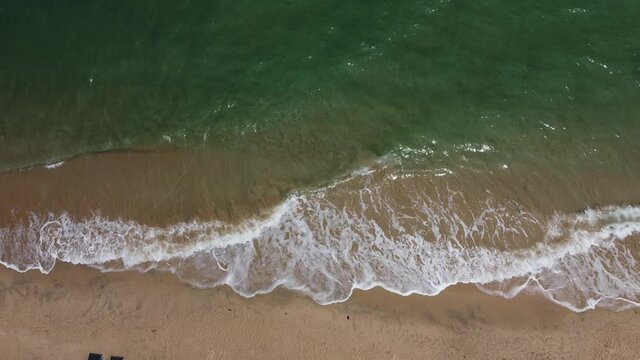 4K on Aerial view of clear turquoise sea on sandy beach and ocean with waves at Sichon Beach, Nakhon Si Thammarat, Thailand.