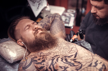 Tattoo master shows the process of tattooing salon