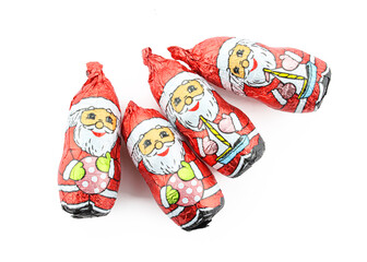 Group of chocolate santa claus figures wrapped in foil isolated on white background