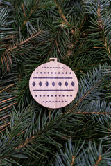 Christmas toy, wooden snowflake, on the branches of a Christmas tree, photo indoors with light