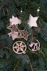 Christmas toys, wooden, on the branches of a Christmas tree, photo indoors with light
