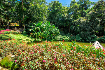 Obraz premium The natural background of colorful flower beds, with chairs to sit and rest while watching the scenery, the wind blows through the blur, cool and comfortable.