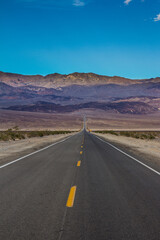 Fototapeta na wymiar Long desert highway leading into Death Valley National Park
