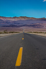 Obraz premium Long desert highway leading into Death Valley National Park
