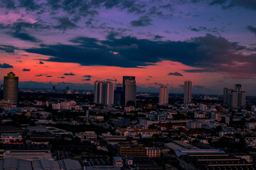 Obraz premium The high angle background of the city view with the secret light of the evening, blurring of night lights, showing the distribution of condominiums, dense homes in the capital community