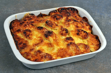 Plat de gratin de pommes de terre maison vu de dessus sur fond gris