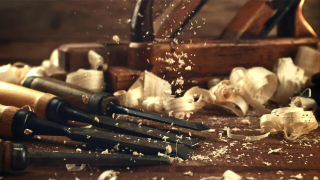 Sawdust falls on a table with chisels. On a wooden background. Filmed is slow motion 1000 frames per second. High quality FullHD footage