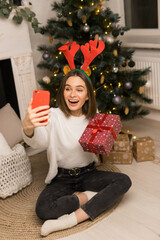 Close up of young girl telephone to parents and show a red Christmas gift