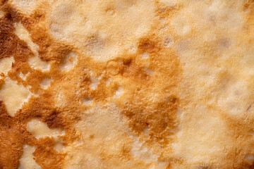 Texture of a cooked thin pancake closeup.