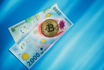 2000 and 1 Romanian leu bills and golden bitcoins. Cryptocurrency investment concept. Crypto mining...