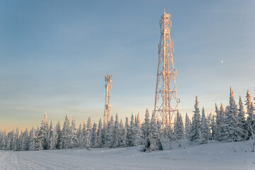 Snow communication towers on the top of the mountain, surrounded by snowy Christmas trees