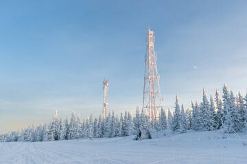 Snow communication towers on the top of the mountain, surrounded by snowy Christmas trees