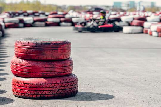 blurred sports car on the go-kart track, front background with a pile of red tires