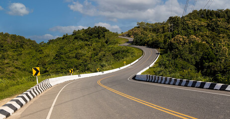 The  curve of the road trough  with green forest with the  nature landscape background