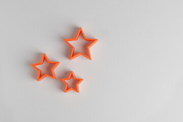 Stars printed on a 3-d printer. Orange plastic stars on white background
