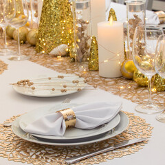 Beautiful table setting with Christmas decorations. Gold colors