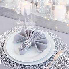Beautiful table setting with Christmas decorations. Silver colors