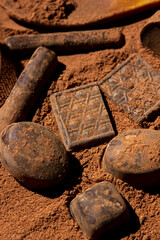 Chocolates lie on cocoa powder. Chocolate making concept. Chocolate sprinkled with cocoa. Cinnamon...