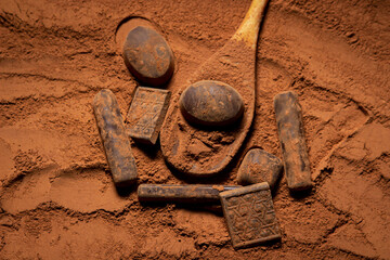 Chocolates lie on cocoa powder. Chocolate making concept. Chocolate sprinkled with cocoa. Cinnamon...