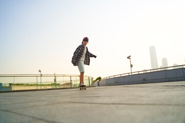 teenage asian boy skateboarding outdoors