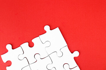 White puzzle pieces on red background, copy space for text.