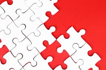 Obraz premium White puzzle pieces on red background, copy space for text.