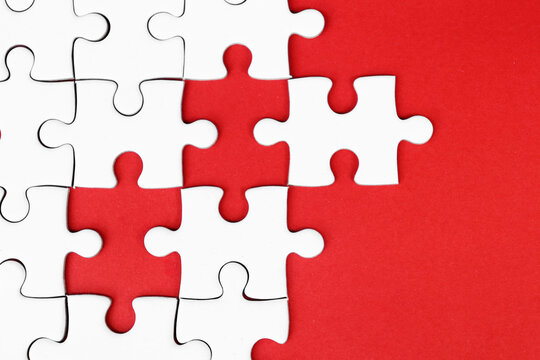 White puzzle pieces on red background, copy space for text.