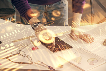 Double exposure of man's hands holding and using a digital device and tech theme hologram drawing. Technology concept.