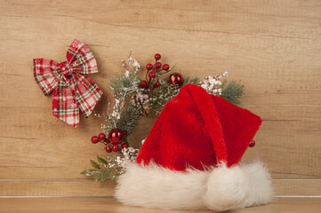 Obraz na płótnie Canvas Santa hat and Christmas decoration on wooden wall. Copy space