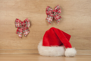 Obraz na płótnie Canvas Santa hat and Christmas decoration on wooden wall. Copy space