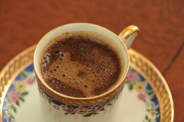 A cup of delicious Turkish coffee. Traditional Turkish Coffee. coffee in porcelain cup with blue decoration with Coffee foam. Close up. 