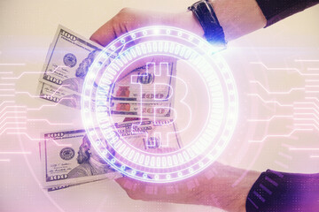 Multi exposure of blockchain theme drawing hologram and USA dollars bills and man hands. Business...