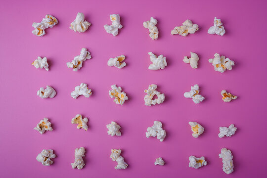 Popcorn lay out on pink background, top view, food pattern