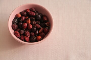 Top view dry rosehips in pink bowl. Heap oof dog rose. Hip of the dogrose.	
