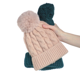 Beige pink and green warm hats in hand on white background isolation