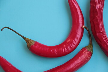 Red hot chili peppers on a blue background. Cayenne pepper, long red pepper, spur pepper