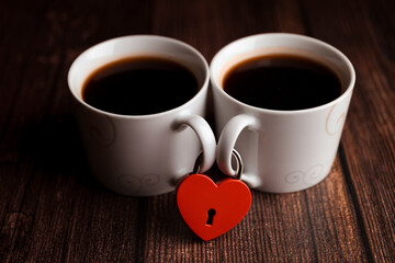 two coffee mugs are fastened with a red heart-shaped lock, Valentine's Day, the concept of love