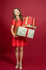 Joyful woman with a gift on a red background