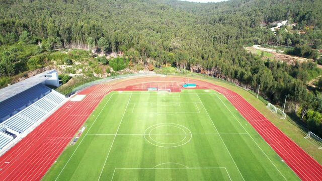 DRONE AERIAL FOOTAGE: The Manuela Machado Municipal Stadium, in Viana do Castelo, Portugal. Empty red running sports tartan track synthetic rubber on the athletic stadium.