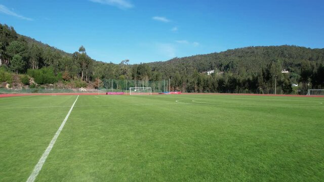 DRONE AERIAL FOOTAGE: The Manuela Machado Municipal Stadium, in Viana do Castelo, Portugal. Empty red running sports tartan track synthetic rubber on the athletic stadium.