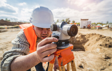 Surveyor worker with theodolite equipment at construction site - obrazy, fototapety, plakaty